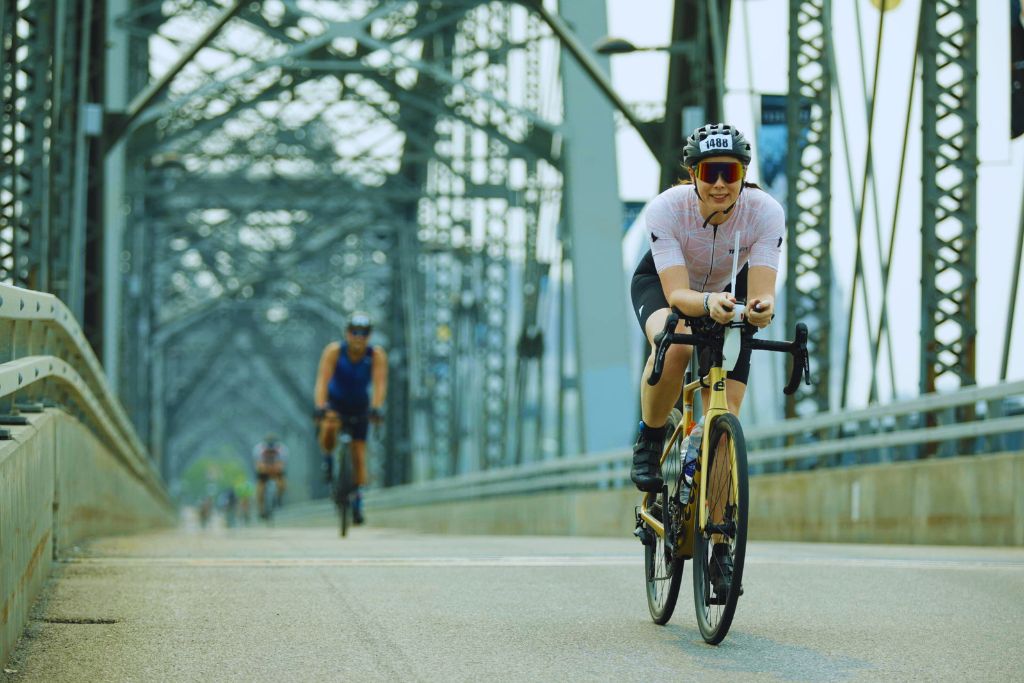 What to eat during an Ironman: an athlete on an Ironman bike course with a front mounted hydration system.
