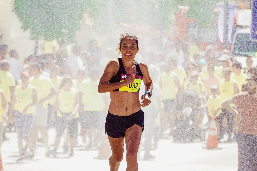 How much does heat affect running pace? A woman running a marathon on a hot day.