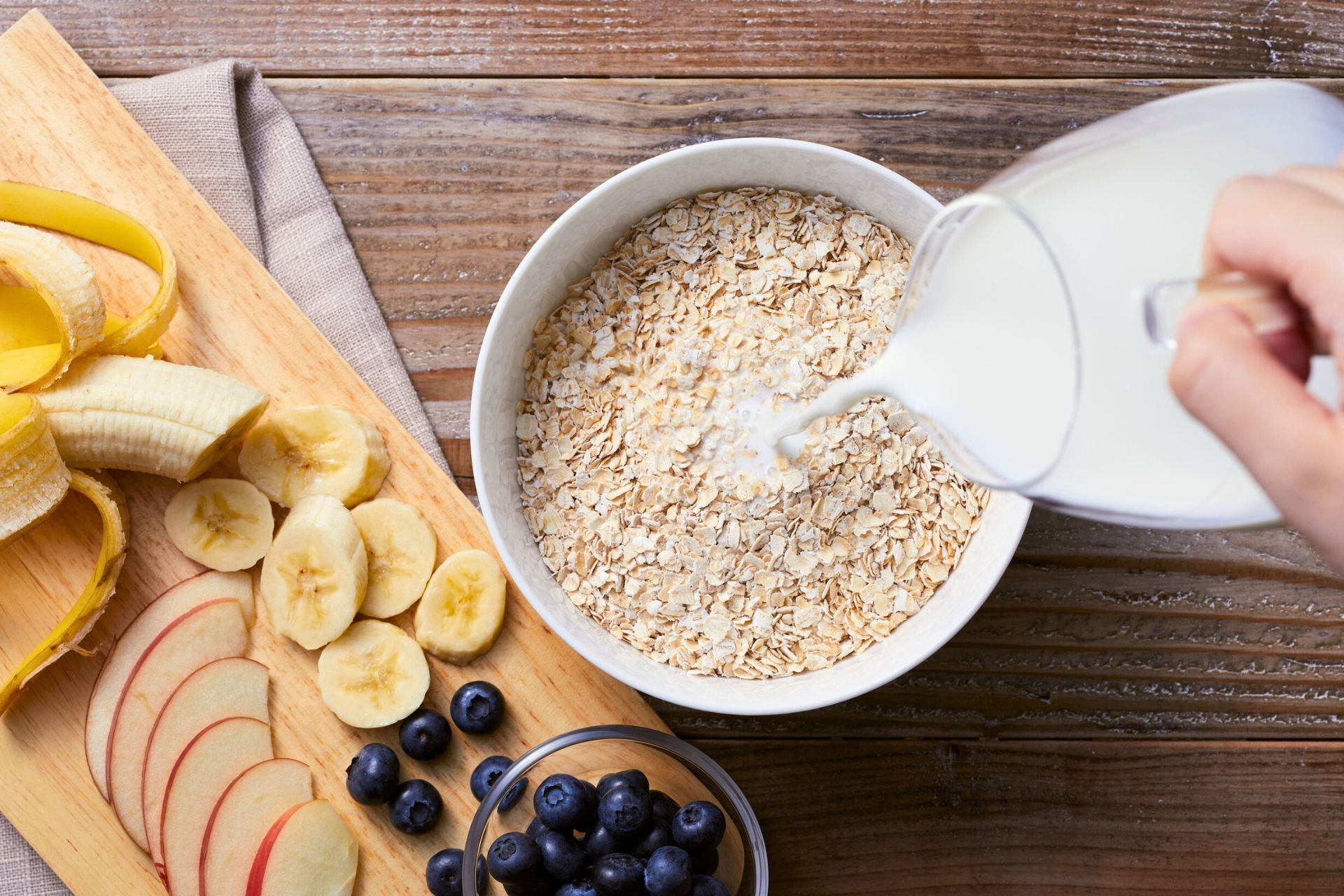 A bowl of oatmeal and some chopped fruit.