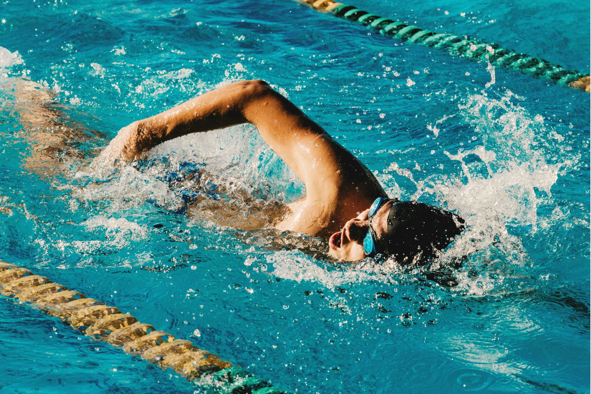 A man doing freestyle in a swimming pool.