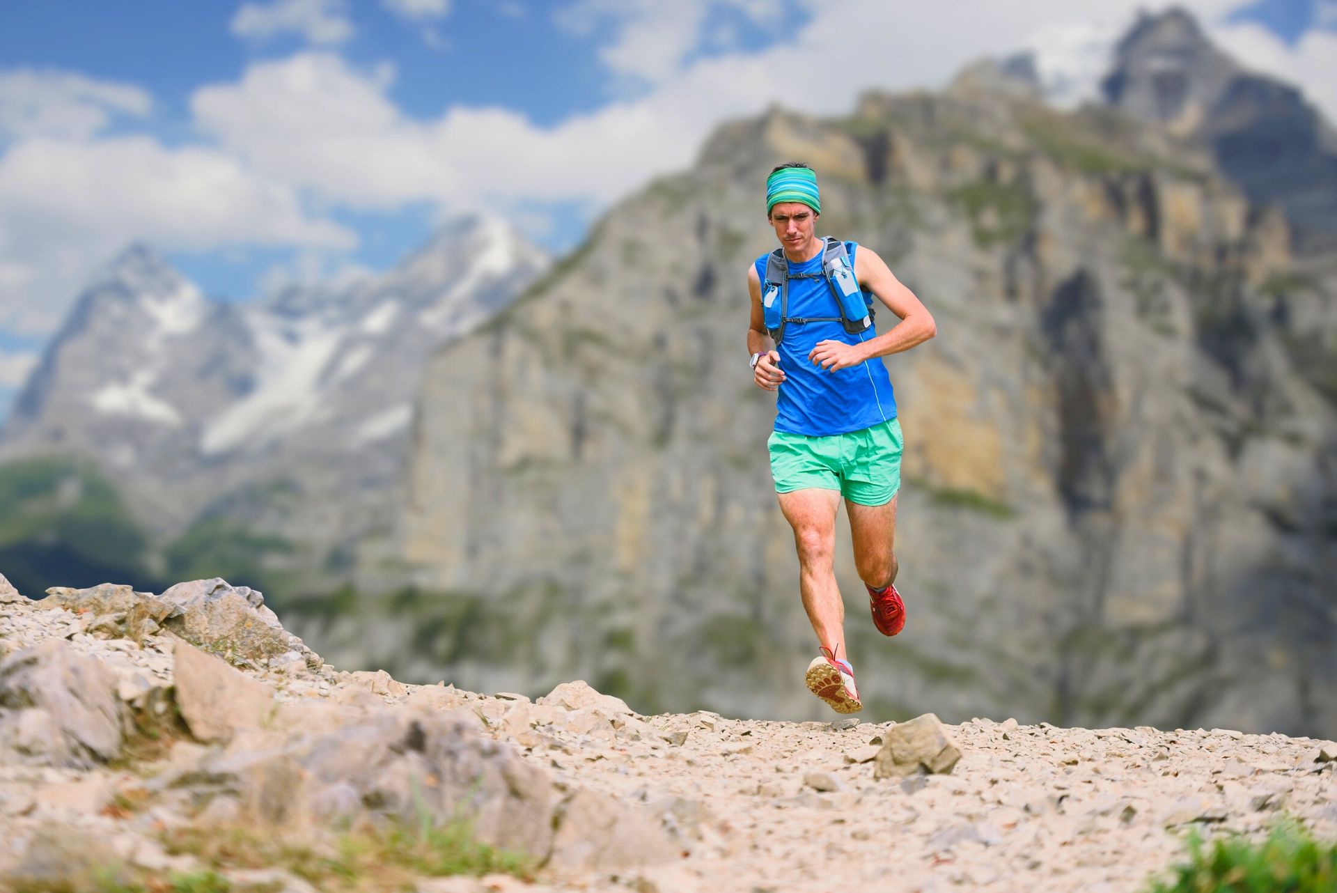 An ultramarathon runner on a mountain trail.
